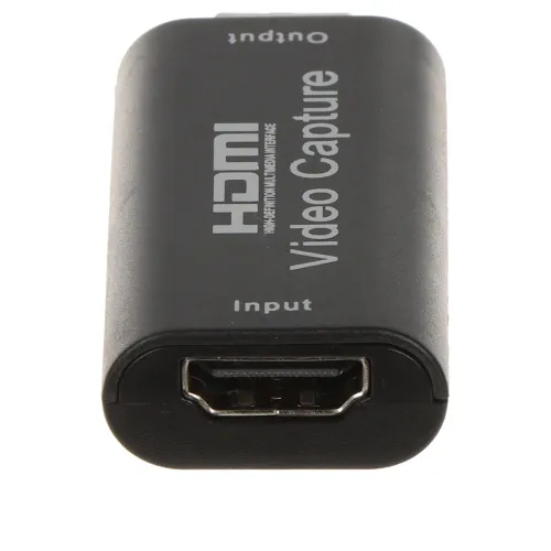 Adapter do przechwytywania wideo z wejściem HDMI i oznaczeniami "Input" oraz "Output". Urządzenie jest czarne z białymi napisami "HDMI Video Capture".
