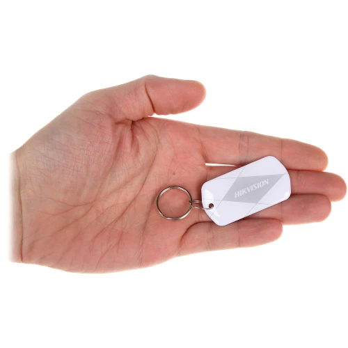 Brelok z białym identyfikatorem marki Hikvision, trzymany w dłoni. Produkt ma prostokątny kształt z zaokrąglonymi rogami i jest wyposażony w metalowe kółko do zawieszenia.