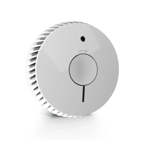 Na zdjęciu znajduje się biały, okrągły czujnik dymu FireAngel FA6115 z centralnym przyciskiem testowym i małym otworem na górze. Urządzenie ma nowoczesny design z widocznymi otworami wentylacyjnymi po bokach.