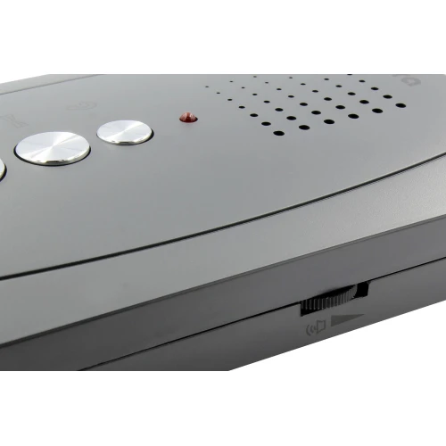 Zdjęcie przedstawia grafitowy domofon Eura ADP-51A3 Difesa z trzema srebrnymi przyciskami i czerwoną diodą. Urządzenie ma elegancki, nowoczesny design z widocznymi otworami głośnika i suwakiem na boku.