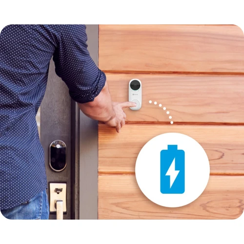 Na zdjęciu widać osobę naciskającą na bezprzewodowy dzwonek WiFi zamontowany na drewnianej ścianie obok drzwi. Obok dzwonka znajduje się ikona baterii, sugerująca zasilanie urządzenia.