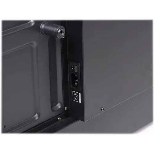 Zdjęcie przedstawia zbliżenie na gniazdo zasilania umieszczone na czarnej obudowie urządzenia. Widać włącznik oraz gniazdo IEC z etykietą wskazującą na zasilanie.