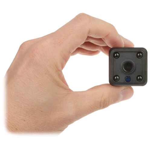 Osoba trzyma w dłoni małą, kwadratową kamerę z czterema widocznymi diodami wokół obiektywu. Kamera jest czarna i kompaktowa, co podkreśla jej niewielki rozmiar.