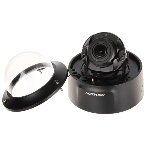 Na zdjęciu znajduje się kamera kopułkowa marki Hikvision z widocznym obiektywem i zdjętym kloszem ochronnym. Obok kamery leży przezroczysty klosz, który chroni urządzenie przed uszkodzeniami i warunkami atmosferycznymi.