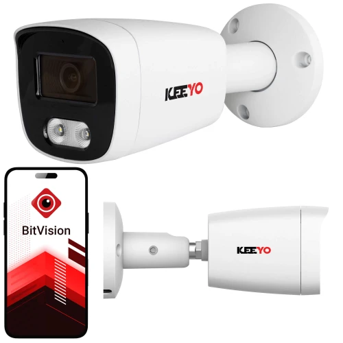 Na zdjęciu znajduje się biała kamera tubowa marki Keeyo zamontowana na ścianie, z widocznym logo na obudowie. Obok kamery pokazany jest smartfon z aplikacją BitVision na ekranie.