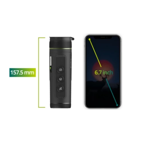 Na zdjęciu znajduje się monokular termowizyjny obok smartfona z ekranem o przekątnej 6,7 cala, z zaznaczoną długością monokularu wynoszącą 157,5 mm. Monokular jest czarny z widocznymi przyciskami na boku, a ekran telefonu pokazuje sylwetkę jelenia na tle zachodzącego słońca.