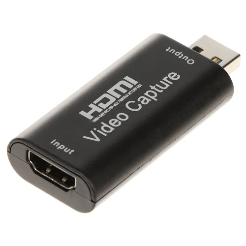Czarny adapter HDMI na USB z napisem "HDMI Video Capture" oraz oznaczeniami "Input" i "Output". Urządzenie służy do przechwytywania sygnału wideo.