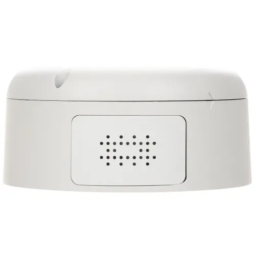 Na zdjęciu znajduje się biała, okrągła syrena alarmowa z widocznymi otworami wentylacyjnymi na przedniej części obudowy. Urządzenie ma gładką powierzchnię i minimalistyczny design.