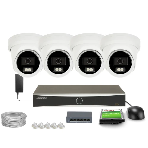 Zestaw do monitoringu składający się z czterech białych kamer kopułkowych, rejestratora, dysku twardego, kabla, switcha i złączek. Kamery są ustawione w rzędzie nad rejestratorem, a pozostałe akcesoria są rozmieszczone poniżej.