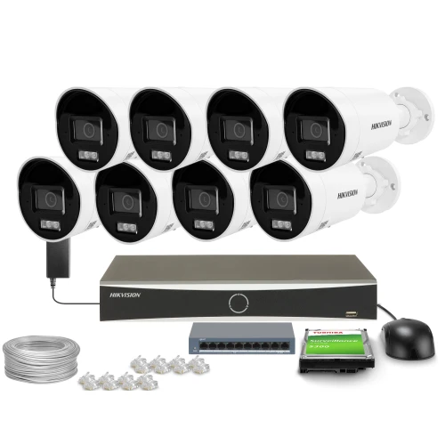 Na zdjęciu znajduje się zestaw do monitoringu składający się z ośmiu białych kamer, rejestratora, dysku twardego, myszki, kabla oraz złączek. Wszystkie elementy są uporządkowane na białym tle, co podkreśla ich profesjonalny charakter.