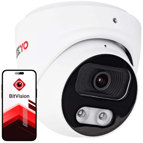 Biały, kopułowy aparat monitoringu z czarnym obiektywem i dwoma diodami LED obok, obok którego znajduje się smartfon z aplikacją BitVision na ekranie. Aparat ma czerwone logo na boku.