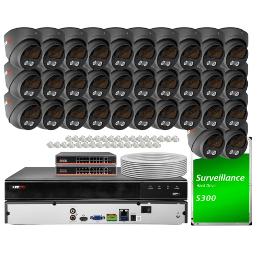 Zestaw do monitoringu składający się z wielu kamer, rejestratora, dysku twardego oraz kabli. Elementy są rozmieszczone na białym tle, ukazując pełny zestaw do instalacji systemu nadzoru.